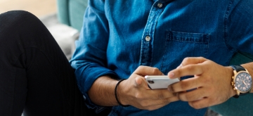 A person scrolls on their cell phone.