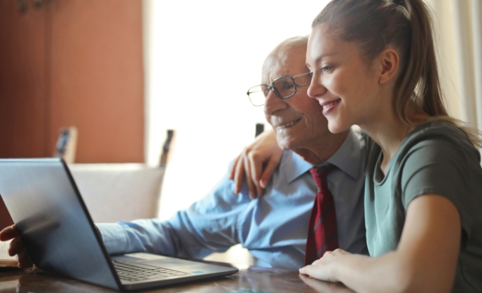 A daughter helps her father select a rate plan on GrandBridge Energy's website.