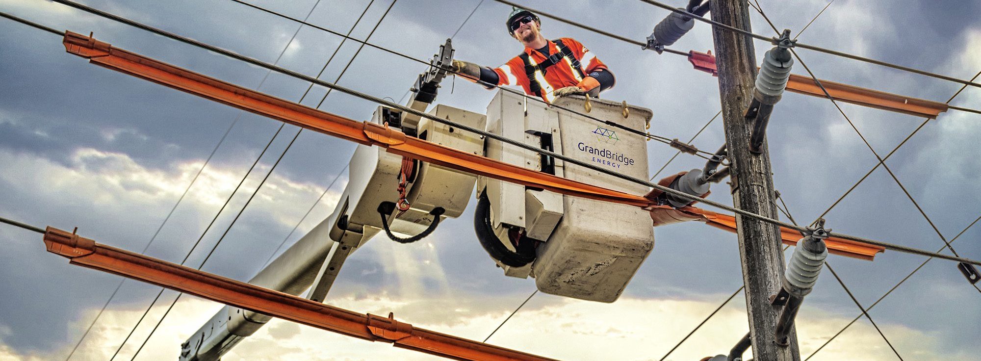 A man in a boom lift fixes overhead powerlines