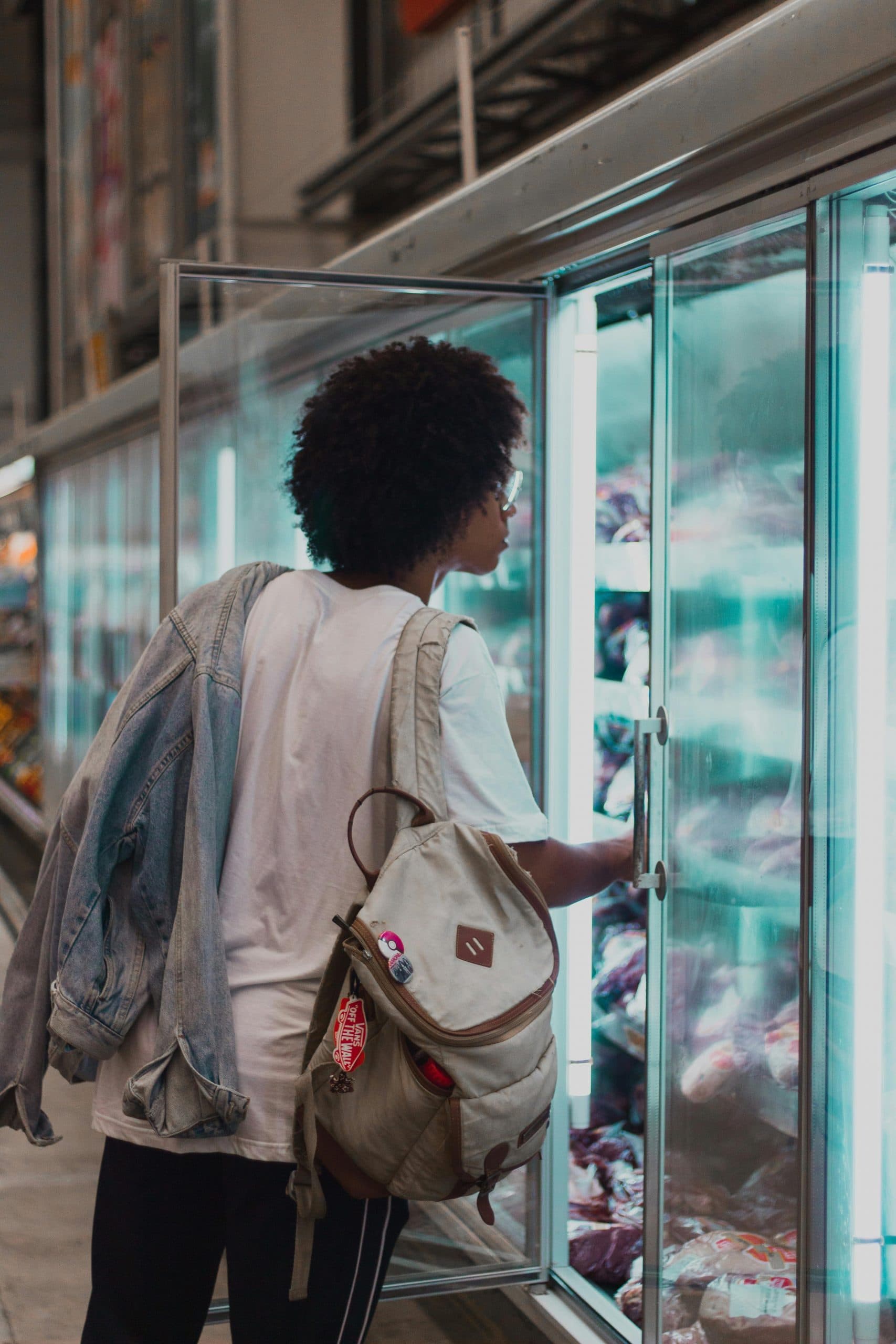 A shopper browses a large store refrigerator.