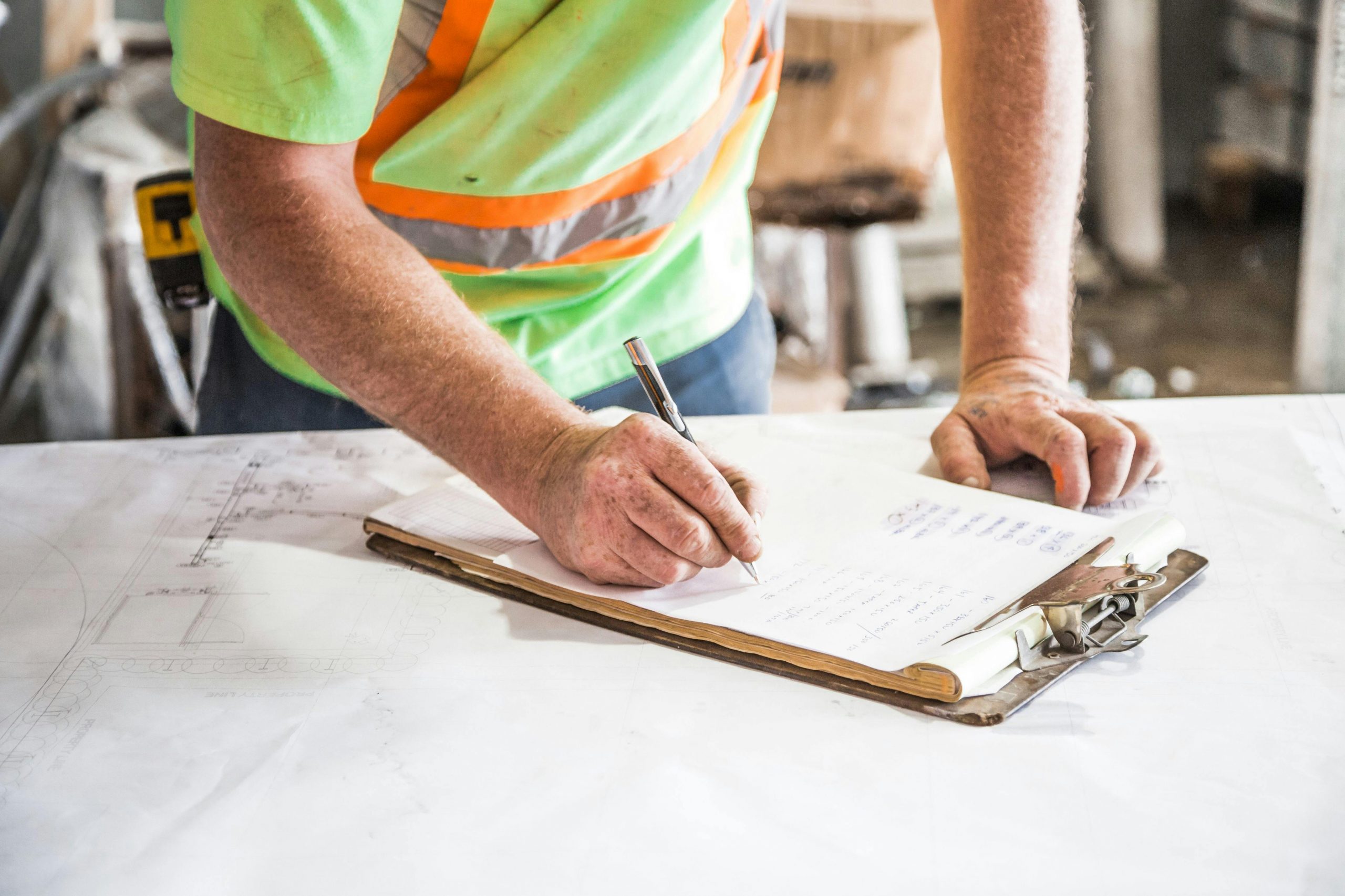 Image of a worker signing a contract sheet while working.