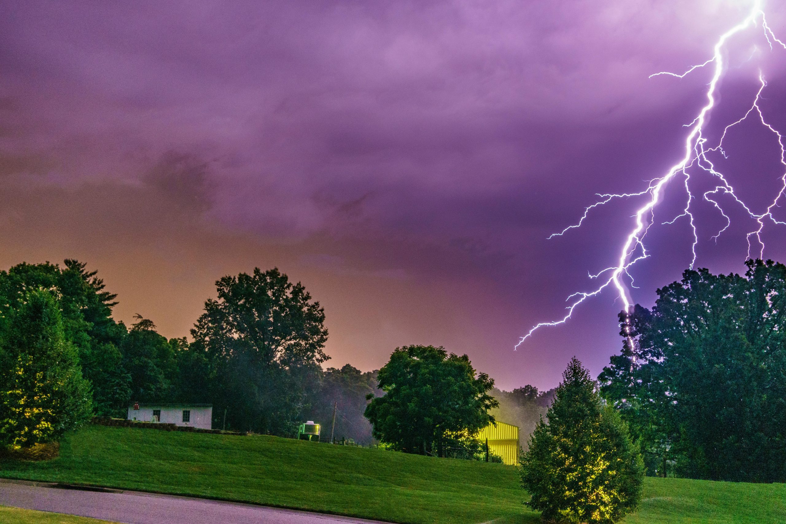 lightning illuminating a neighbourhood with green grass