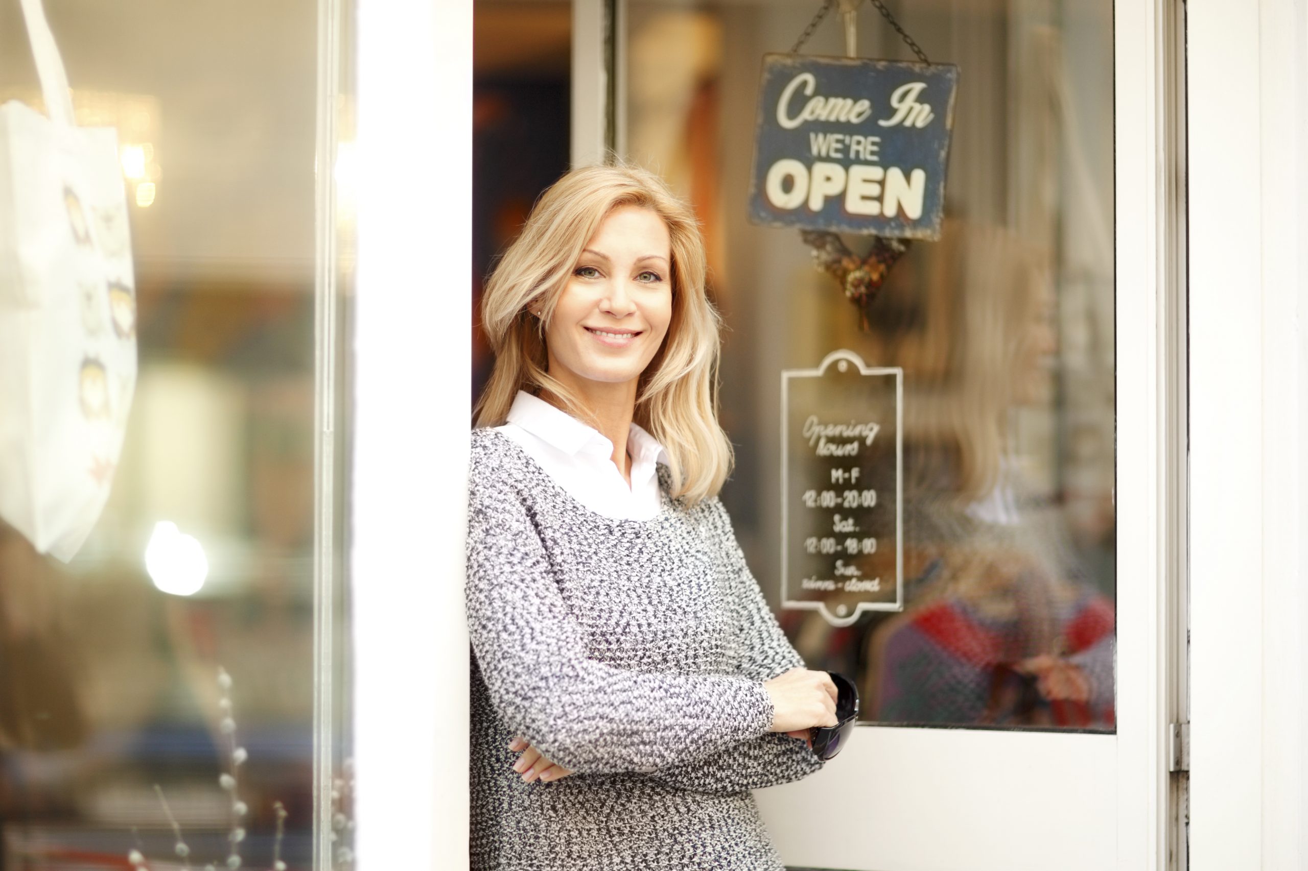 A business owner stands in a doorway.