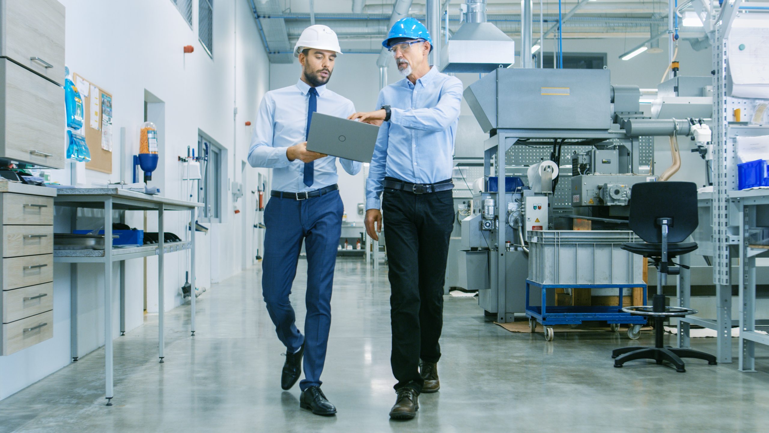 Two industrial workers review their facility energy consumption