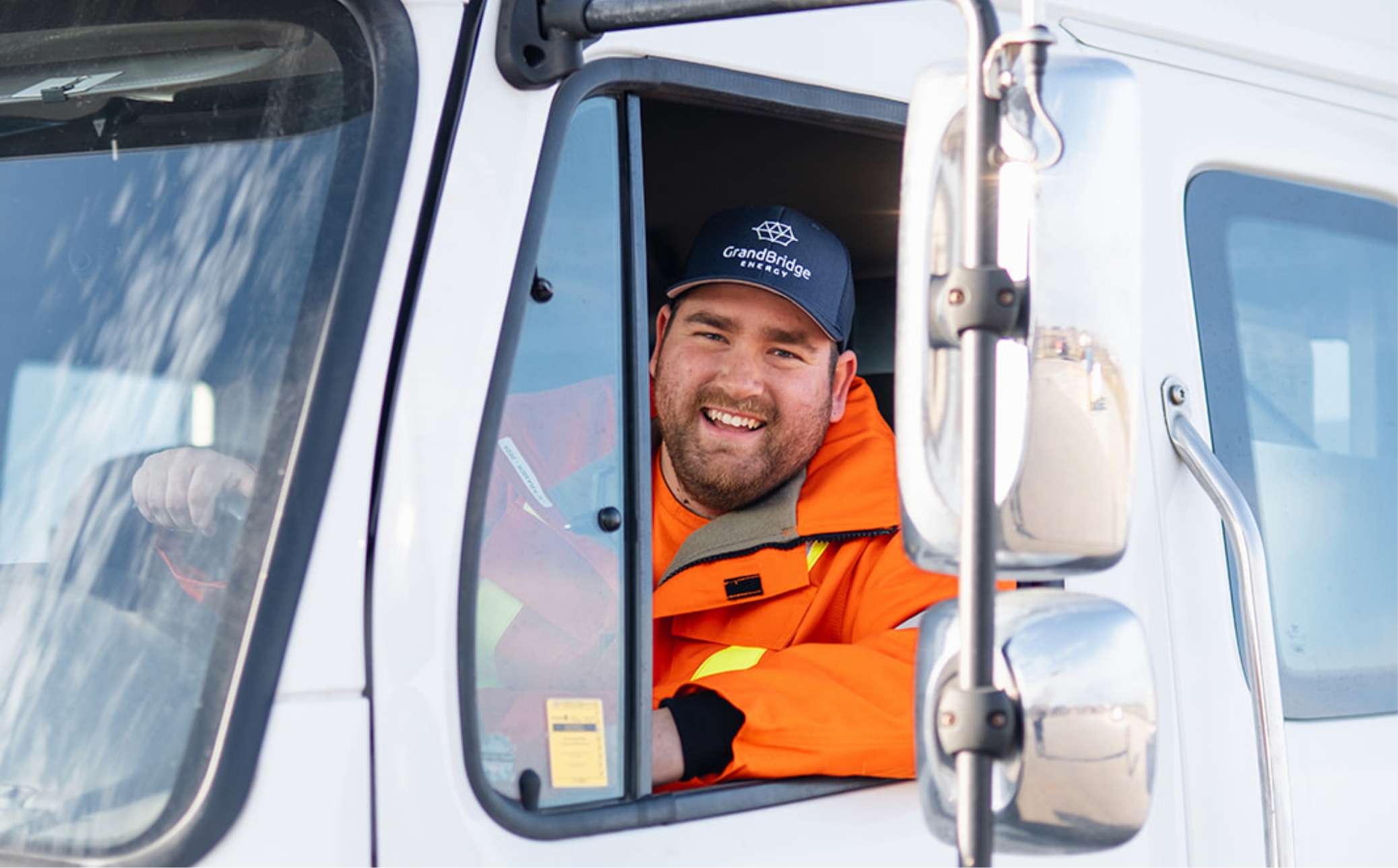 GrandBridge Energy powerline technician smiling while driving one of the trucks.