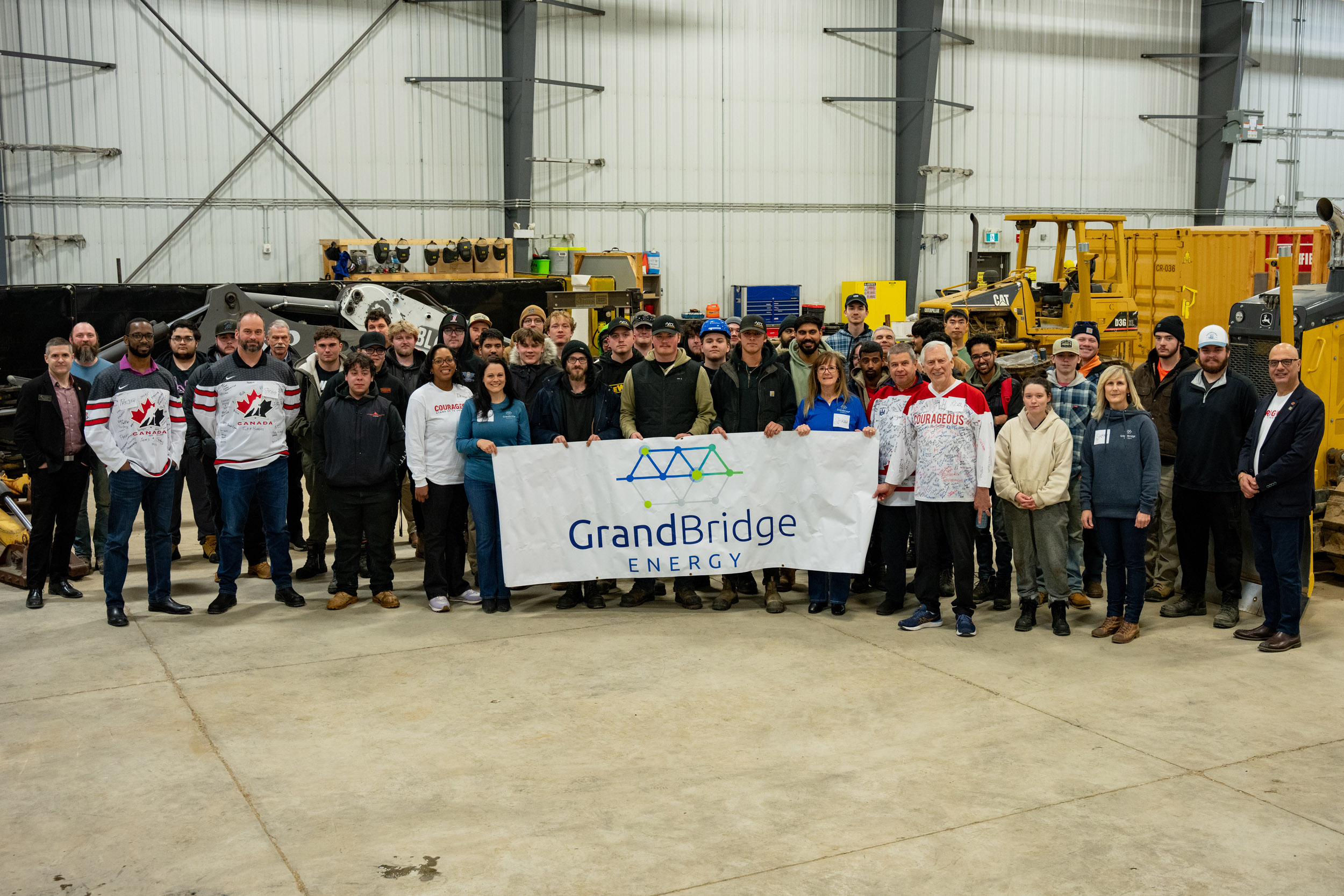 Group of people holding grandbridge banner. They are learning about safety at work.