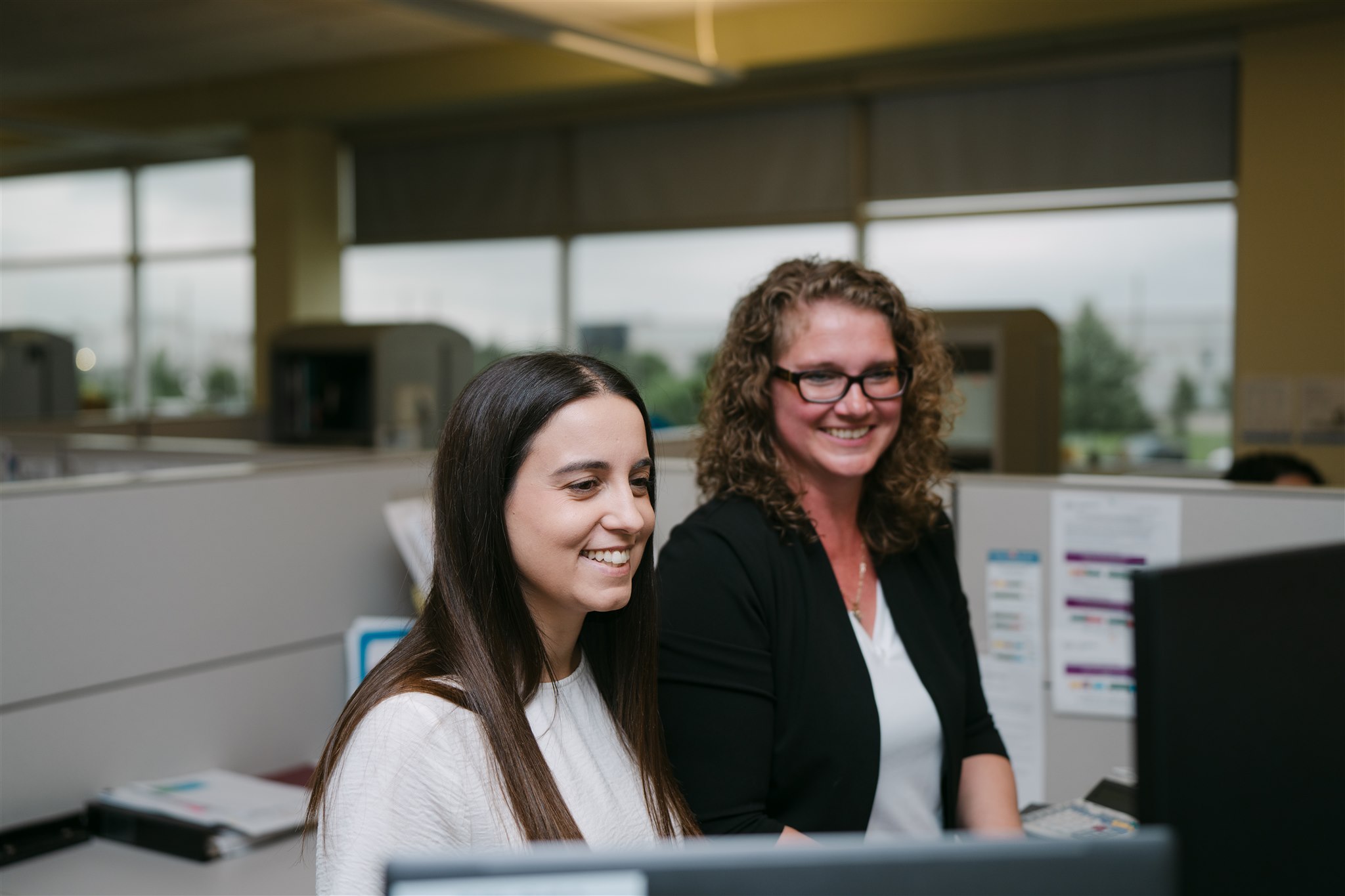 Two Customer Service Representatives work together to solve customer inquiries.