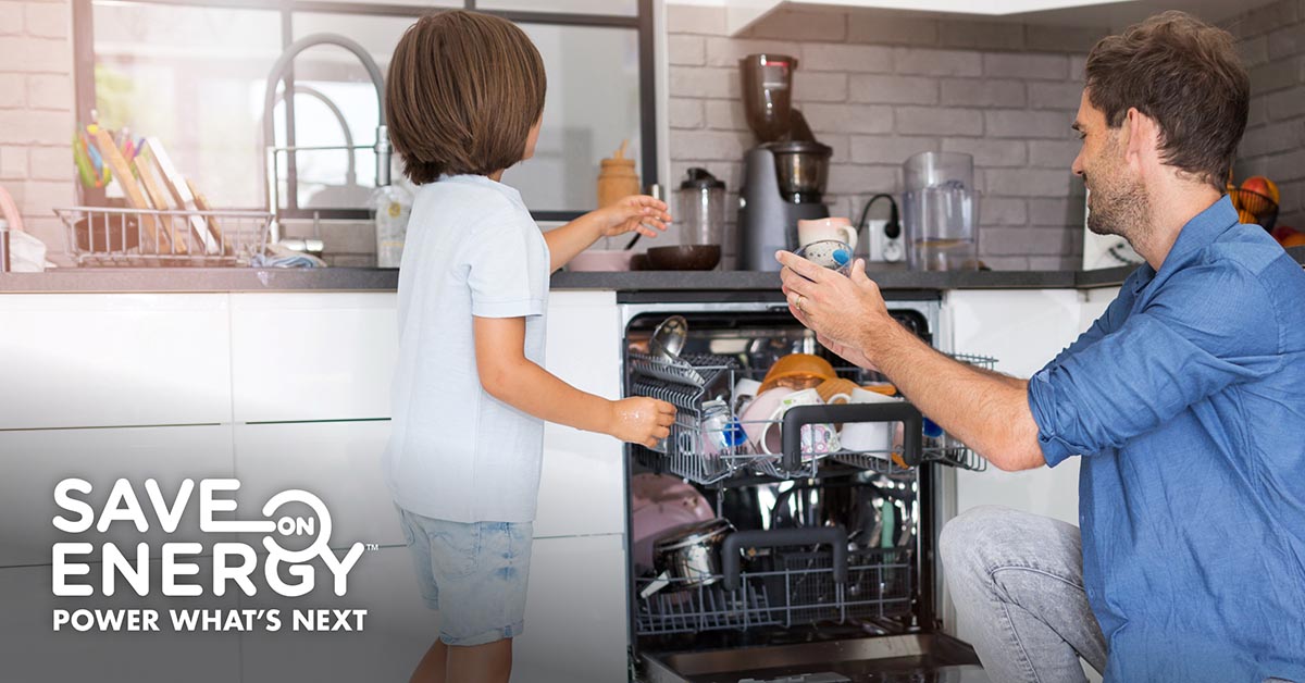 Man and child unload dishwasher