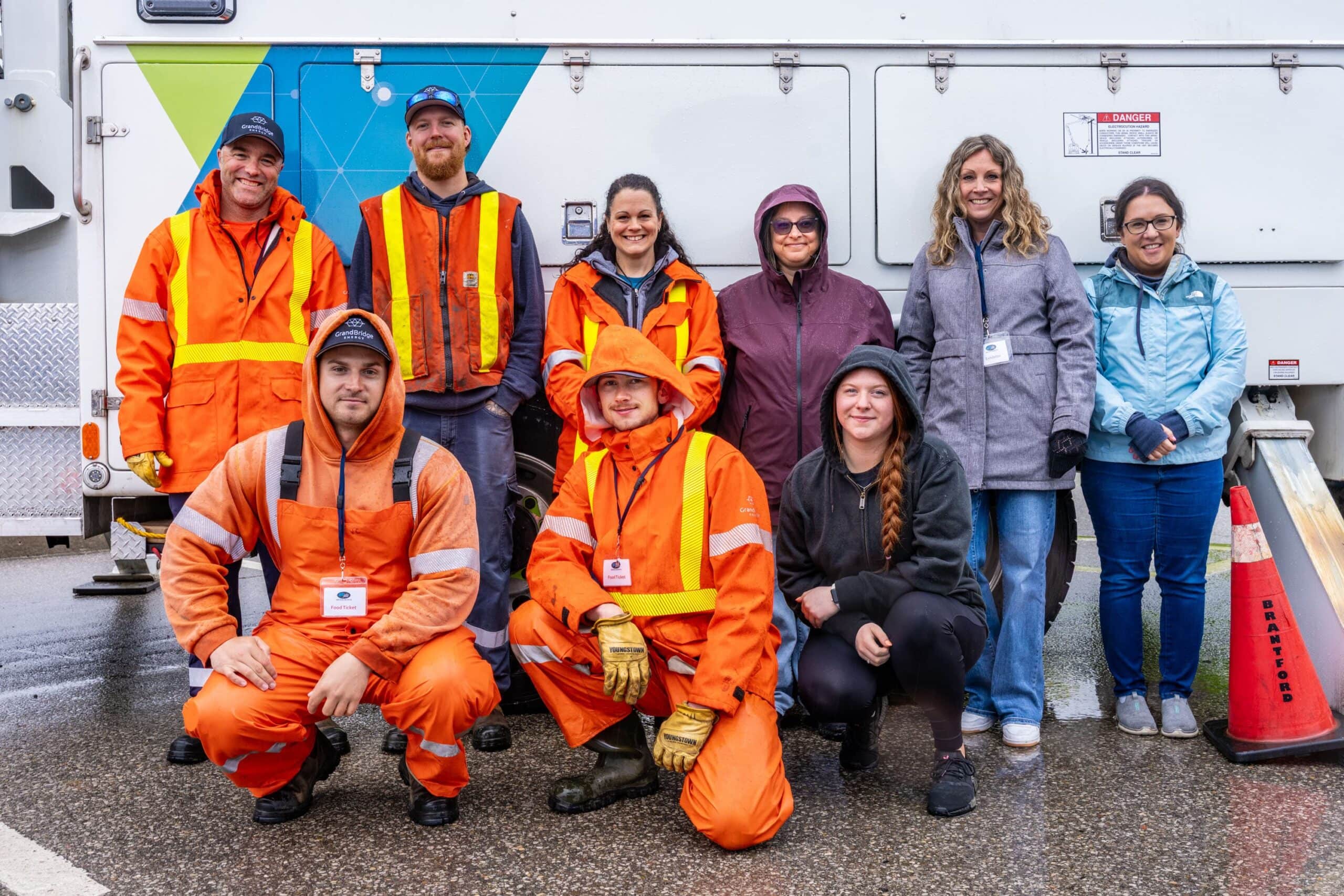 Group of employees stands outside in front of utility truck during a job fair.