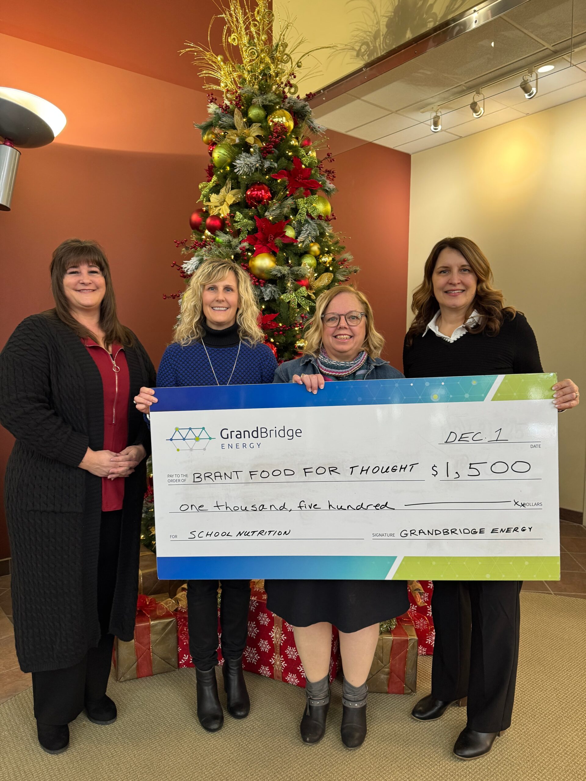 Employee holds large cheque for Food for Thought.