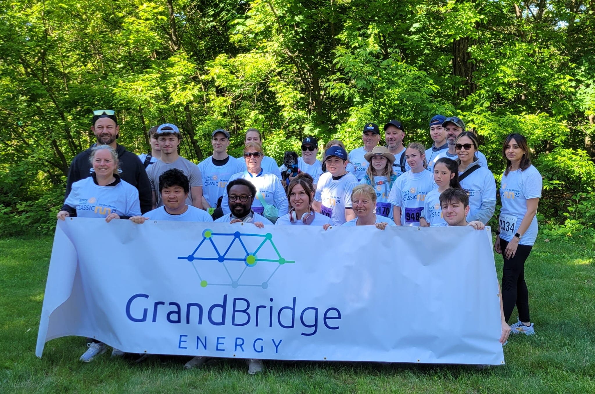 Employees posing behind a company banner after a charity run.