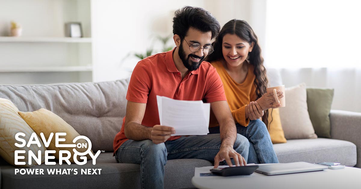 Couple looking at their hydro bill and determining potential savings.