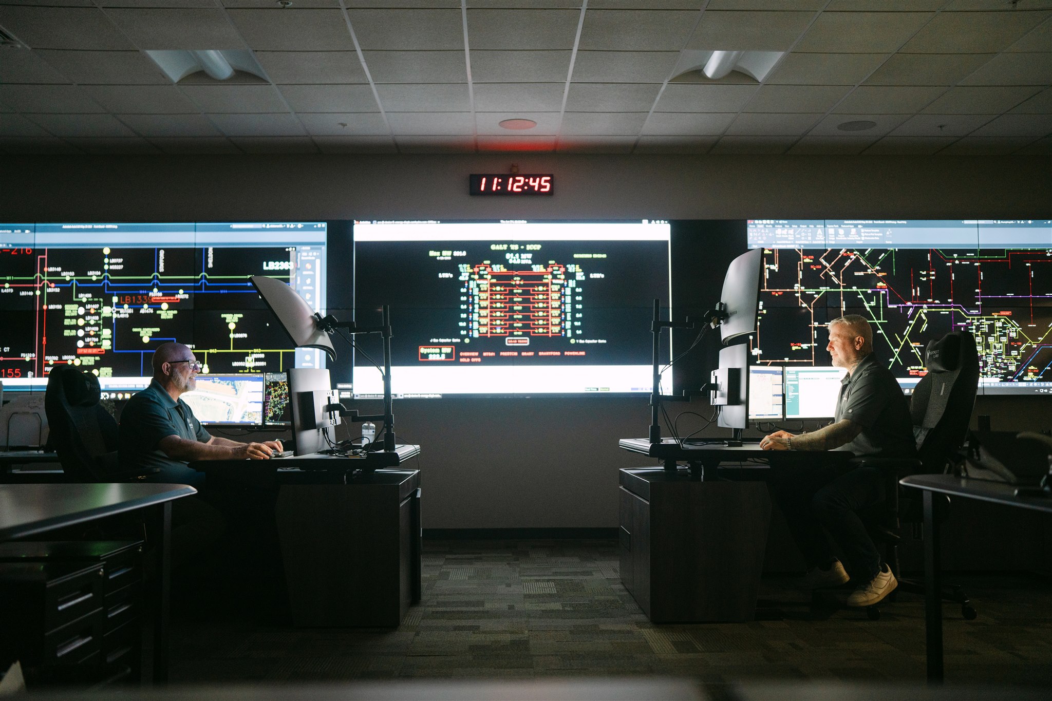 two professionals looking at an electronic chart data in Grandbridge control room